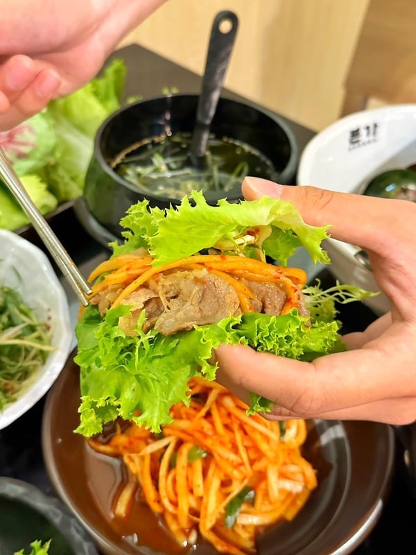 烤好的肉片加上1~3種生菜再與白鍾元「本家特製海鮮包醬」搭配一起入口