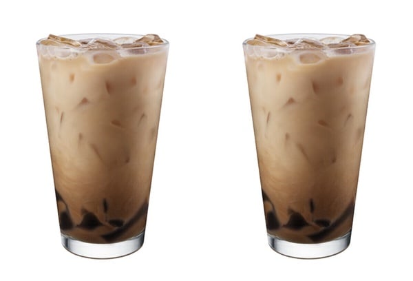 冰的星巴克福吉茶那堤加配料黑糖葛粉，裝在透明玻璃杯中