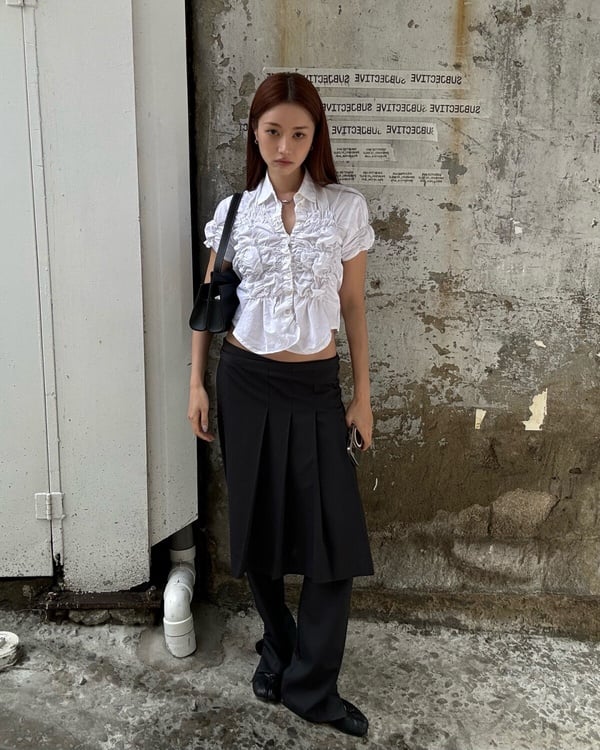 一名女子示範白襯衫 Smart Casual 穿搭，以白色短袖襯衫搭配黑色長褲裙與黑色娃娃鞋，展現知性風格