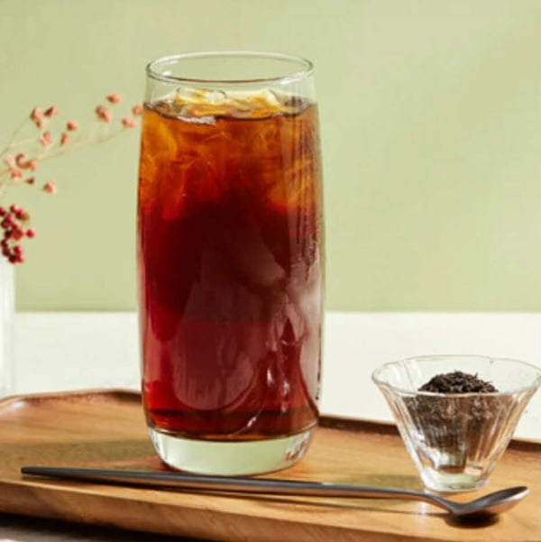 拾汣茶屋菜單上19元飲品「拾汣紅茶」，以透明杯裝著，呈現清澈的琥珀色茶湯。