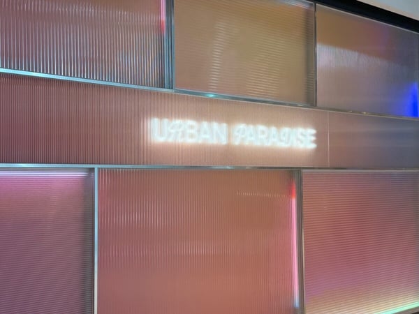 URBAN PARADISE 餐廳入口的精緻品牌牆面，以光影設計營造質感氛圍