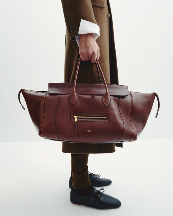 模特兒手提 CELINE Smiling Luggage 包，展示其作為手提包時的尺寸比例與極簡風格。