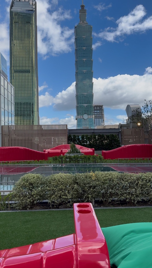 星巴克典藏DREAM PLAZA台北7樓的戶外座位區，顧客在此喝咖啡，並可抬頭欣賞台北101的壯麗景色。