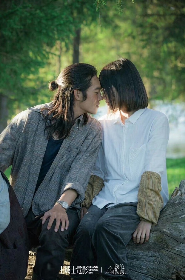 陸劇《我的阿勒泰》劇照，于適飾演的哈薩克少年巴太與周依然飾演的李文秀坐在樹上甜蜜互動。