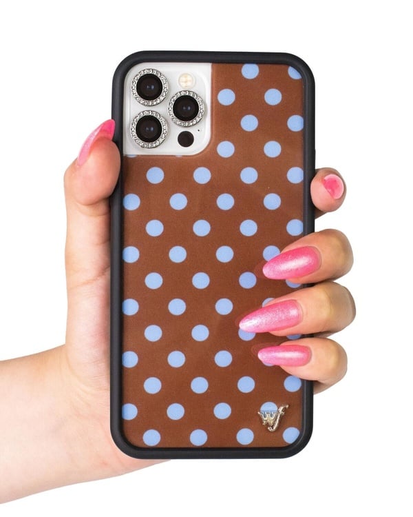 一支裝有透明手機殼的iPhone，其鏡頭上安裝了Wildflower品牌的閃亮水鑽鏡頭保護環，作為低調奢華的點綴。