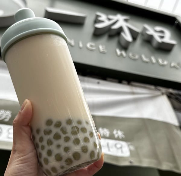 一沐日招牌逮丸奶茶，杯中裝有草仔粿製成的特色配料，為2025推薦必喝