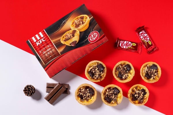 肯德基聯名KITKAT新品「奇巧可可流心三重奏蛋撻」特寫，蛋撻上方鋪滿巧克力醬與KITKAT威化碎，呈現誘人的光澤