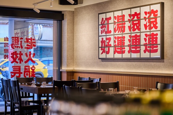 馮校長老火鍋台北東區店的內部裝潢，以木桌椅與復古標語打造校園風格。