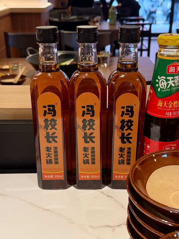 馮校長老火鍋的道地「油碟」沾醬，最適合搭配涮好的肉片浸入裝滿蒜泥與蔥花的香油碟中。
