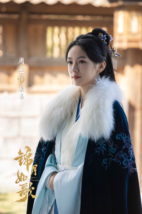 周也在《錦月如歌》飾演一名重生歸來的女將軍，劇裡有女扮男裝從軍的故事線。周也的長相清冷，劇裡毛領搭配男裝、女裝都很有亮點，有種美麗但不可接近的距離感。